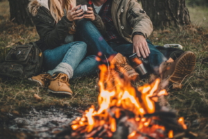 Traveler couple camping in the forest and relaxing near campfire after a hard day - conditional green card removal concept.