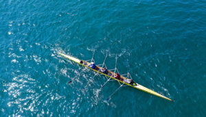 Competitive rowing in a large body of water.