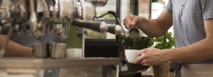 Man preparing coffee using professional machine, panorama