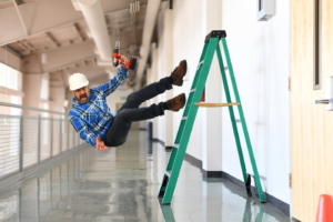 Construction worker falling off a ladder inside a building.