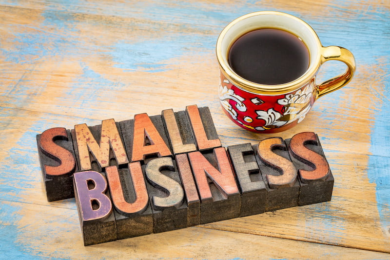 small business - text in vintage letterpress wood type printing blocks with a cup of coffee - dba concept