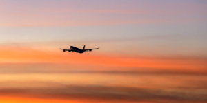 commercial airliner taking off at lax flying into twilight sky of southern california