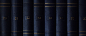 Blue law books on a shelf with gold numbering. Virginia Laws Concept