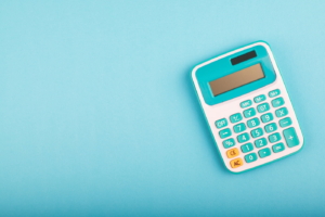 Close-up and selective focus shot of a calculator on blue background. Pain and suffering concept.