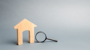Wooden house and magnifying glass. Property valuation. Home appraisal.