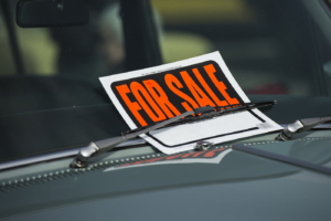 For Sale sign in a damaged car