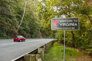 Welcome to Virginia sign located at the Maryland, Virginia state border at Purcellville, Virginia. The black sign has a red heart shape and 'Virginia is for lovers' slogan underneath.