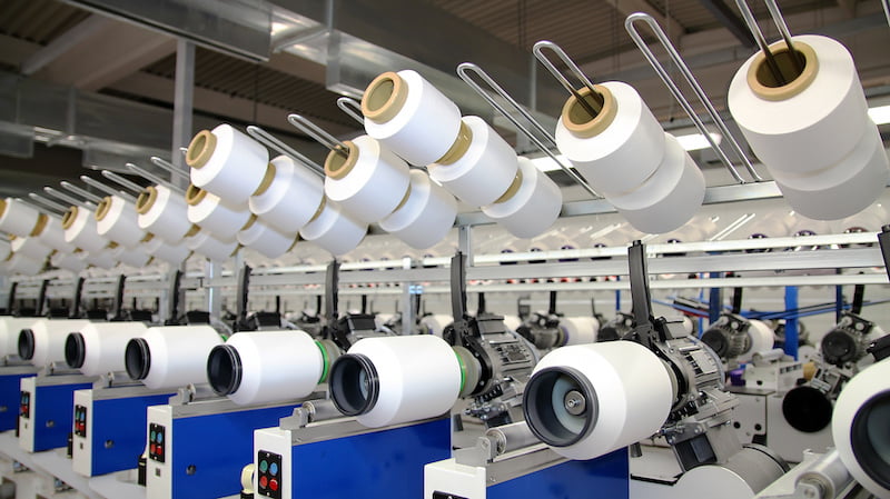 row of automated machines for yarn manufacturing. modern textile plant. textile manufacturing of synthetic fibers.