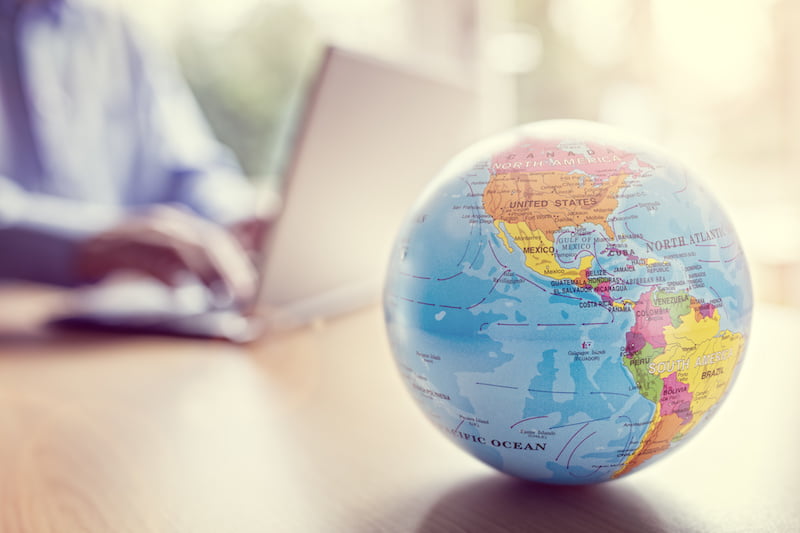businessman using a laptop with close up on world globe.