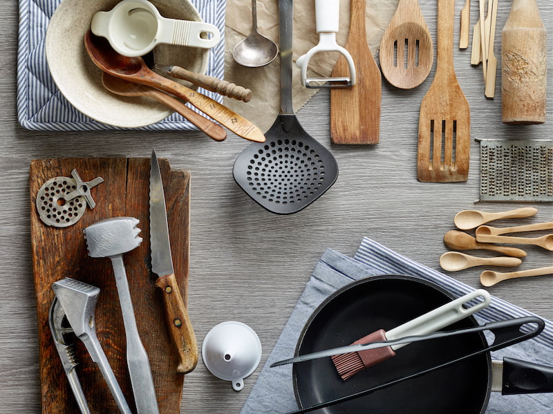 various kitchen utensils on wooden table, top view