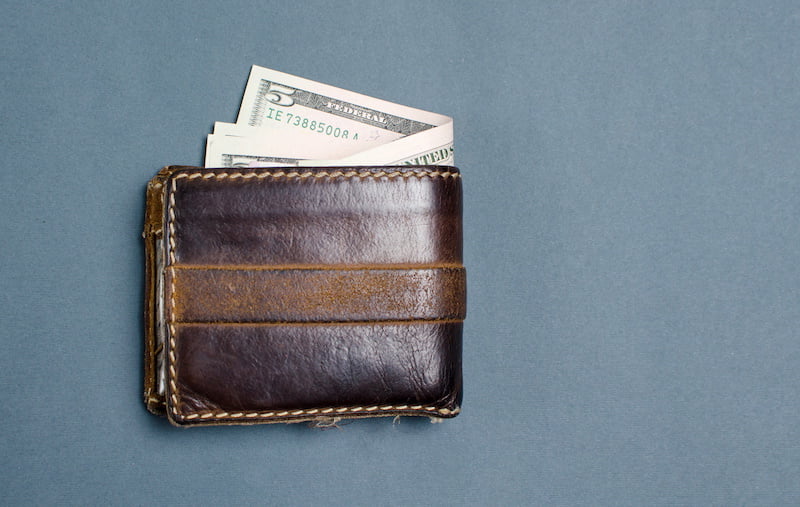 dollar bills in a brown leather wallet