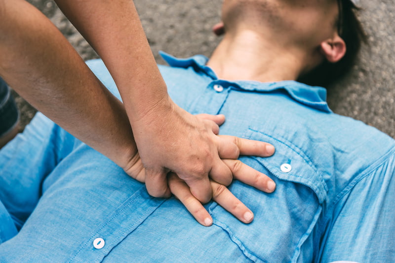 emergency cpr on a man in a blue shirt.
