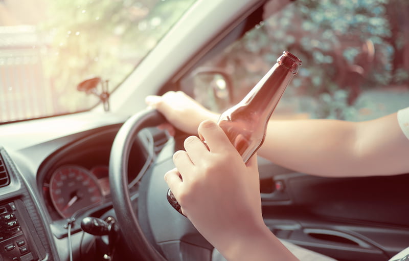 man drinking beer while driving.