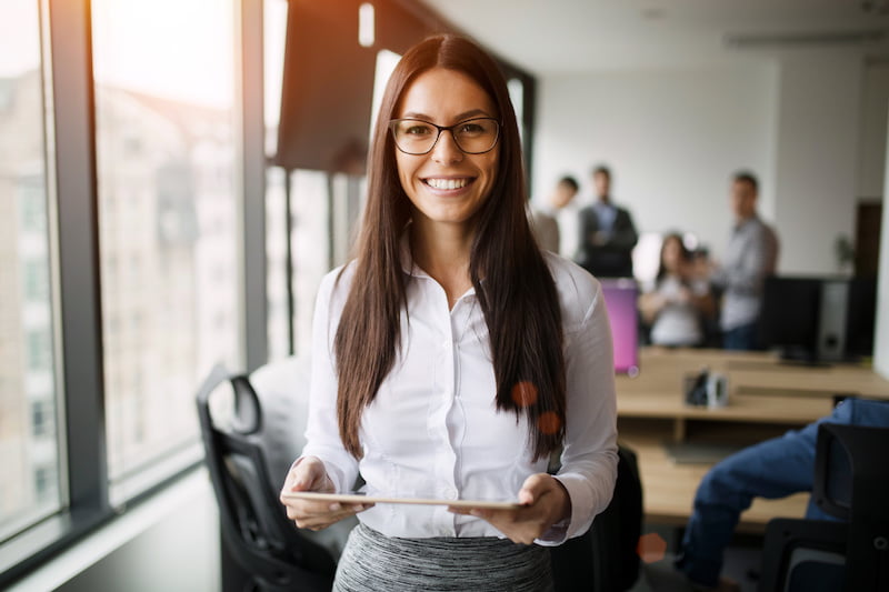 portrait of beautiful young businesswoman holding tablet in office