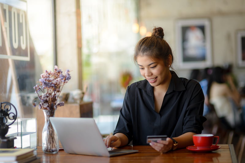 asian woman paying online by laptop at coffee shop, lifestyle concept.