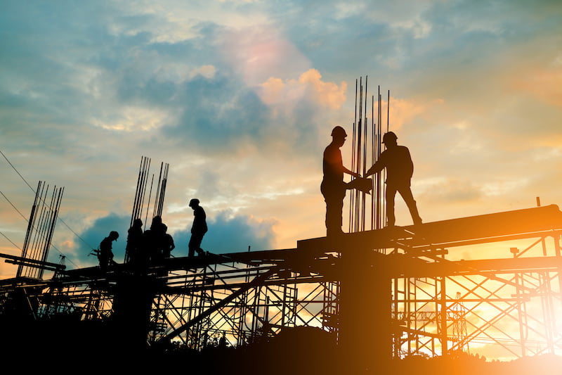 silhouette of engineer and construction team working at site over blurred background sunset pastel for industry background with light fair.