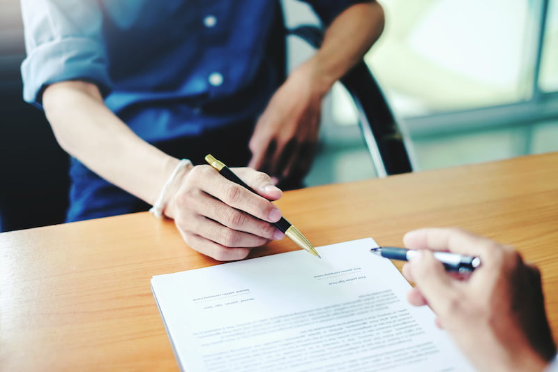 man signing a contract. signing an agreement in a document