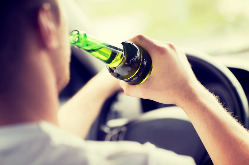 man drinking alcohol while driving.