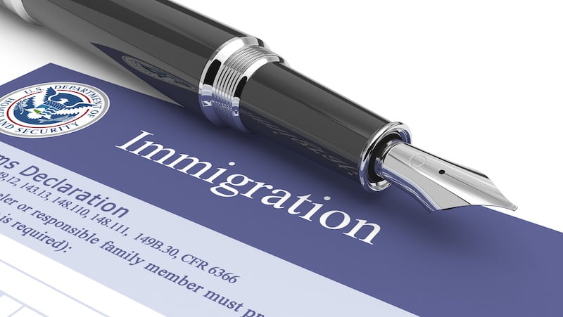 immigration document with a black pen.