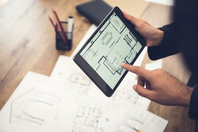 appraising a home for a divorce using blueprints and a tablet.