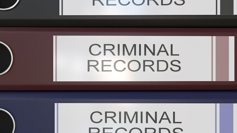 vertical stack of multicolor office binders with criminal records tags
