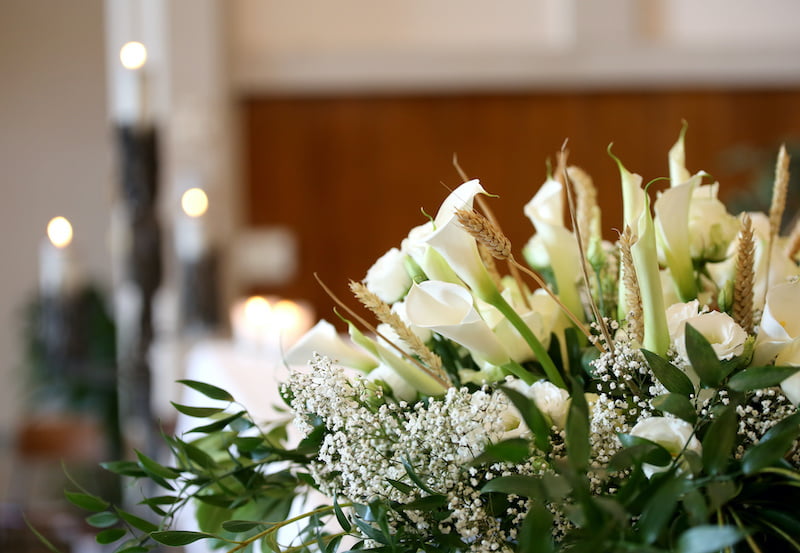 vase of flowers on an altar in the church and the candles on background