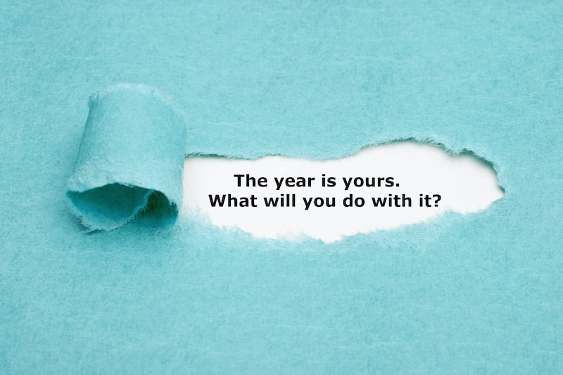 motivational quote the year is yours. what will you do with it? appearing behind torn blue paper.