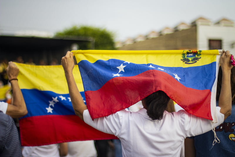lima, lima / peru - february 2 2019: people holding venezuelan flag protesting against nicolas maduro