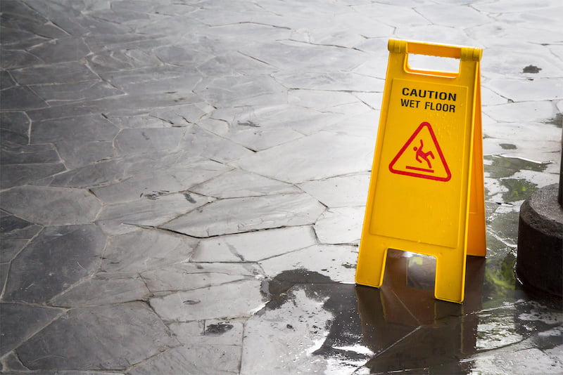 wet floor sign with water drops on wet stone floor