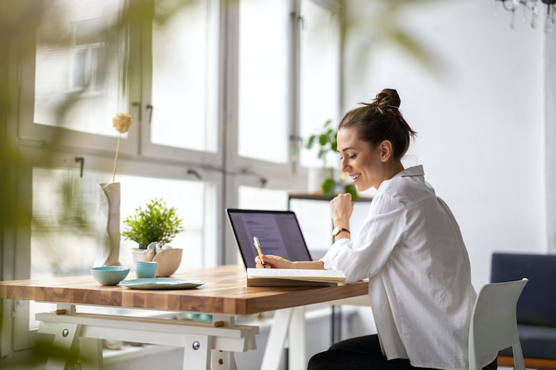 woman working out of her home office on social media posts for small business
