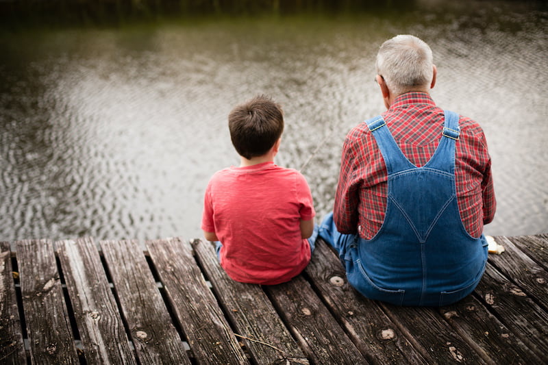 happy great grandfather and grandson fishing together