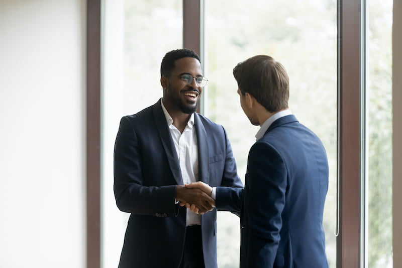 two men shaking hands after doing business in an office.