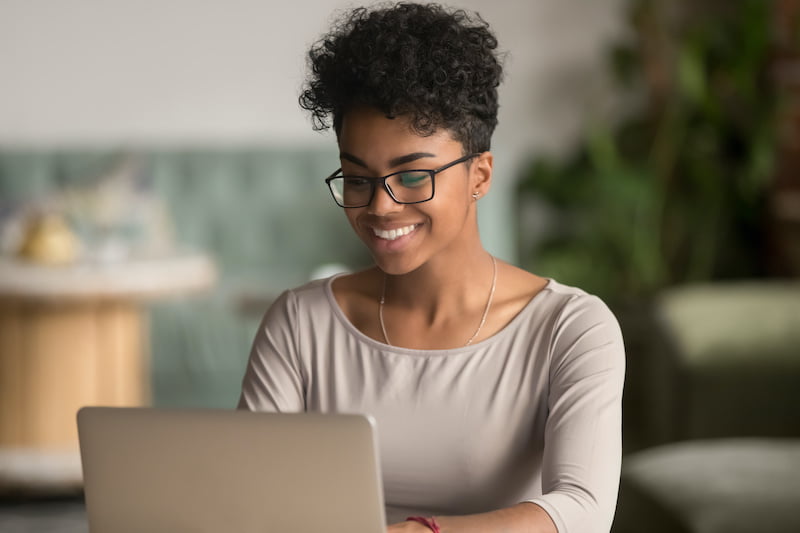 happy african american woman worker using laptop